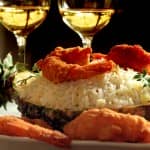 Camarão à dorê servido no abacaxi com arroz de passas e abacaxi salteado