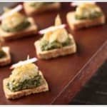 Crostini de queijo de castanha com pesto de manjericão e cebolas caramelizadas Crostini de queijo de castanha com pesto de manjericão e cebolas caramelizadas